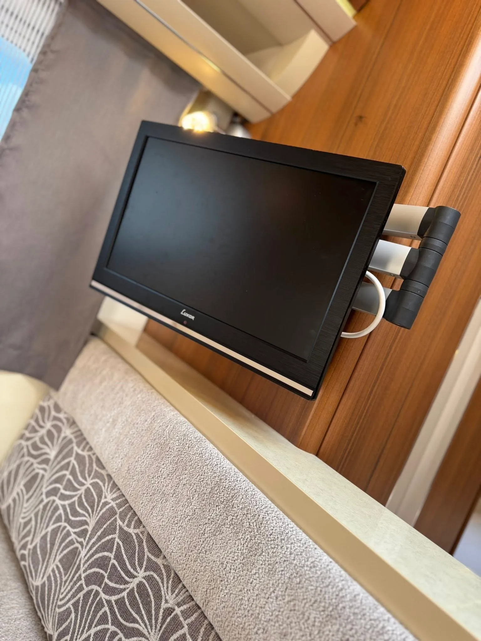 Obrázek zobrazuje interiér s televizí v obytném autě, moderní a pohodlný design pro příjemné cestování.