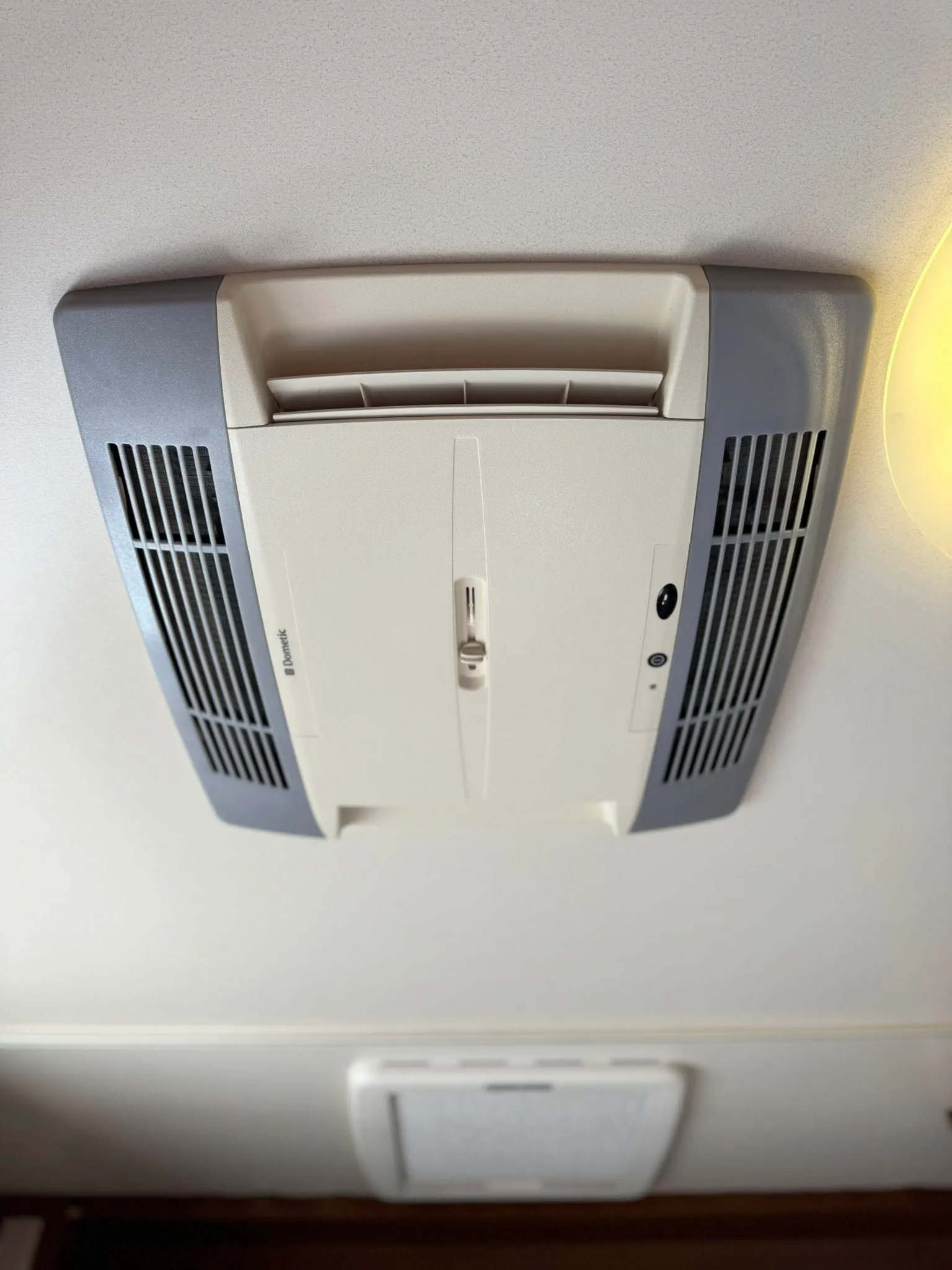 Na obrázku je stropní klimatizace pro obytné auto. Značka a model nejsou viditelné.