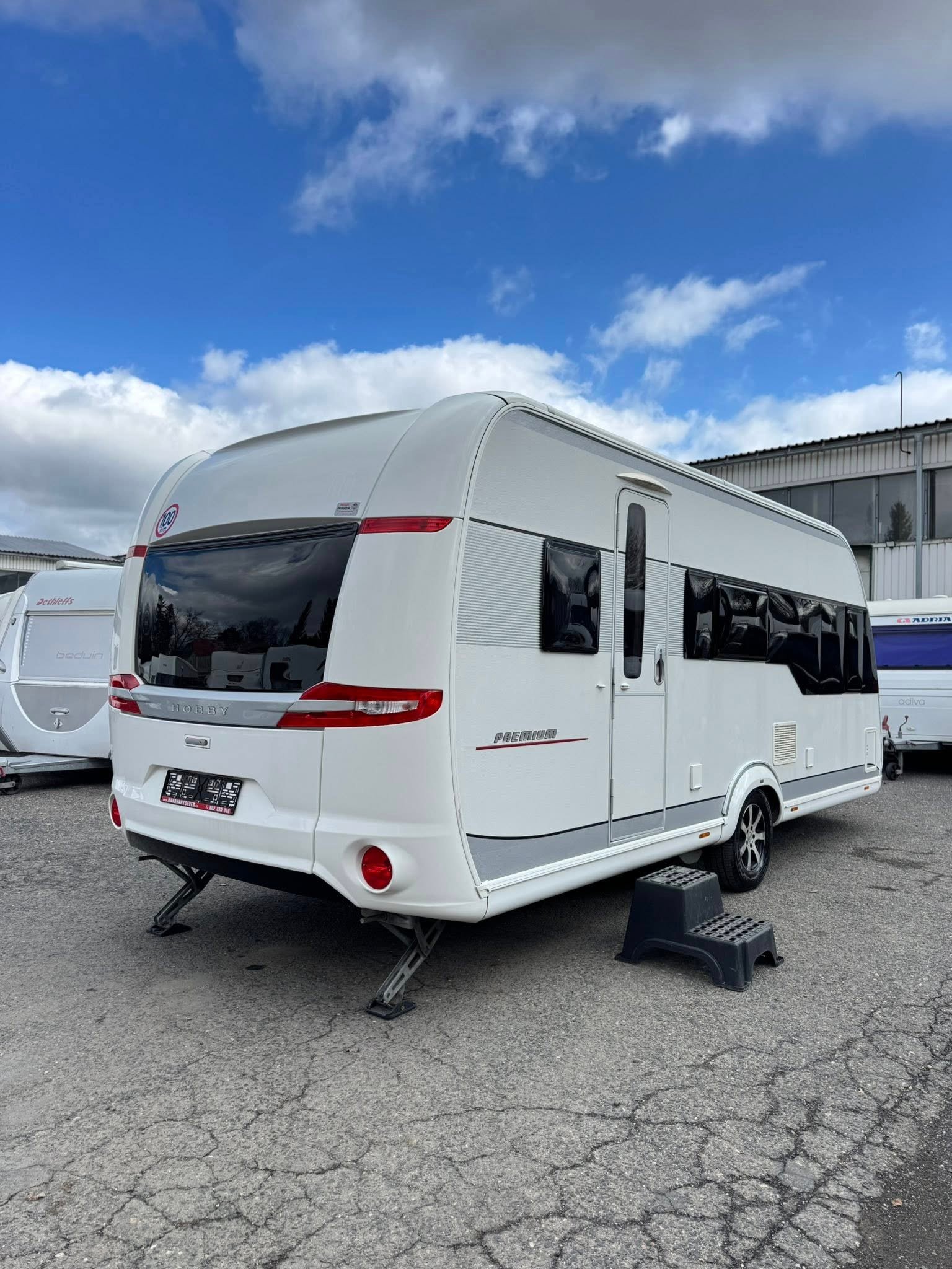 Karavan Hobby Premium, bílý, moderní design, ideální pro rodinné výlety. Prozkoumejte přírodu pohodlně!