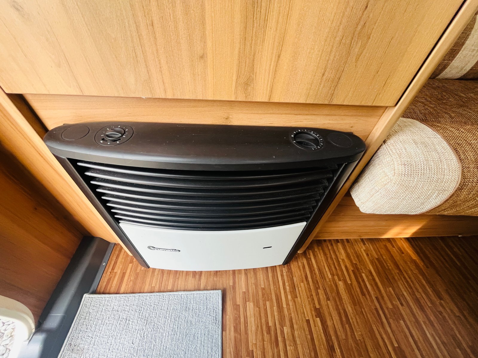 Obrázek ukazuje vyhřívací jednotku v interiéru obytného vozu. Ideální pro pohodlné cestování.