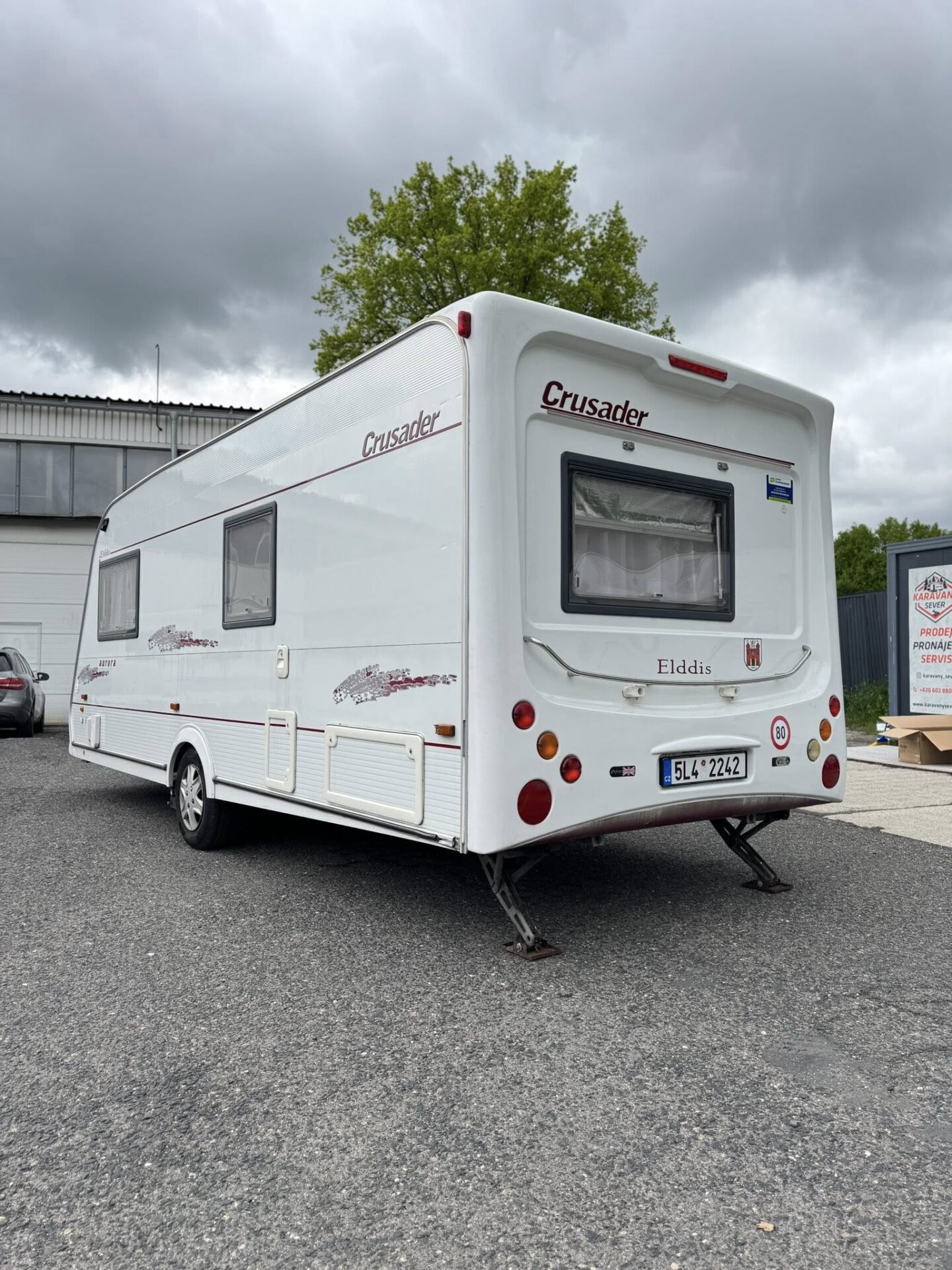 Karavan Elddis Crusader, bílý, s příslušenstvím a zadními světly. Ideální pro cestování a dovolenou.