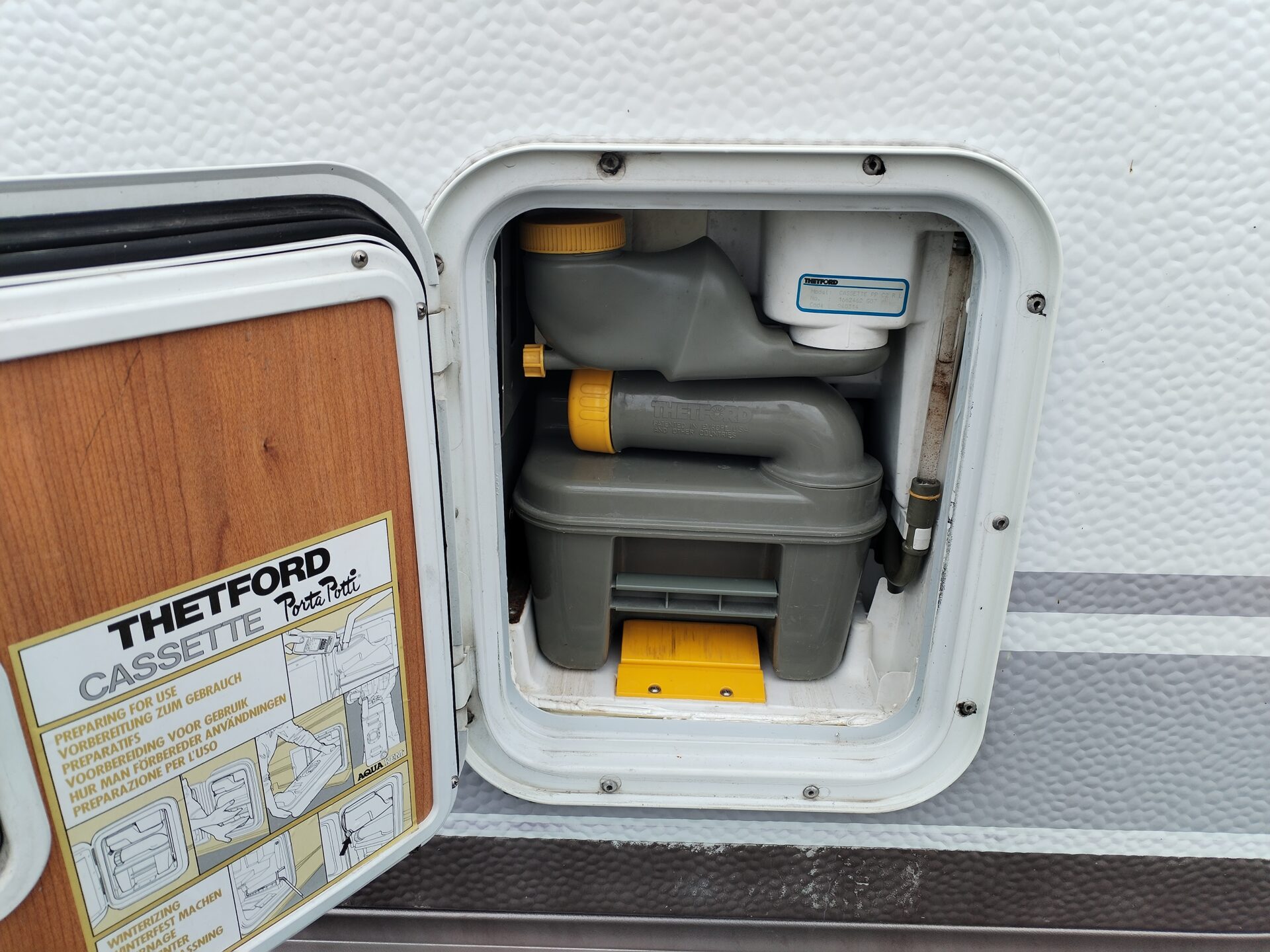 Obrázek ukazuje toaletu Thetford Porta Potti v karavanu. Ideální pro pohodlné cestování.
