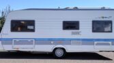 Karavan Hobby De Luxe v bílém provedení, ideální pro pohodlné cestování a rekreaci.