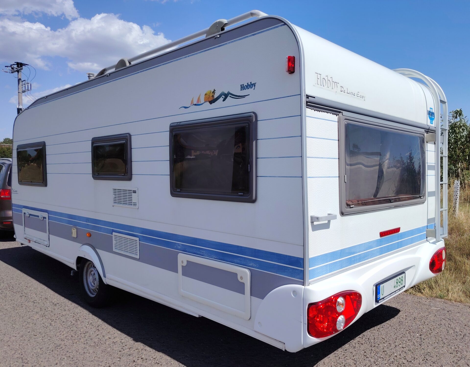 Karavan Hobby s moderním designem a prostornými okny pro pohodlné cestování.