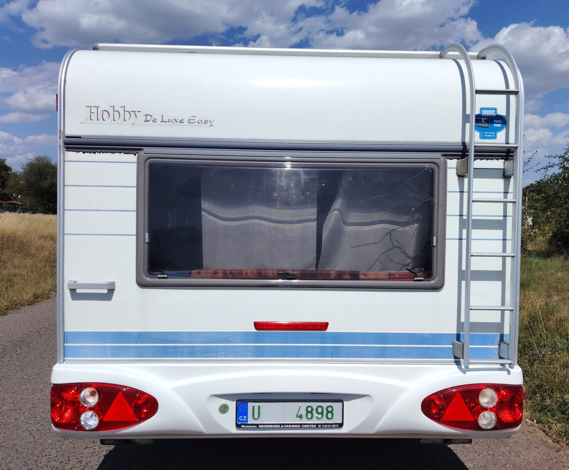 Karavan Hobby De Luxe Easy na slunné cestě, ideální na víkendové dobrodružství.