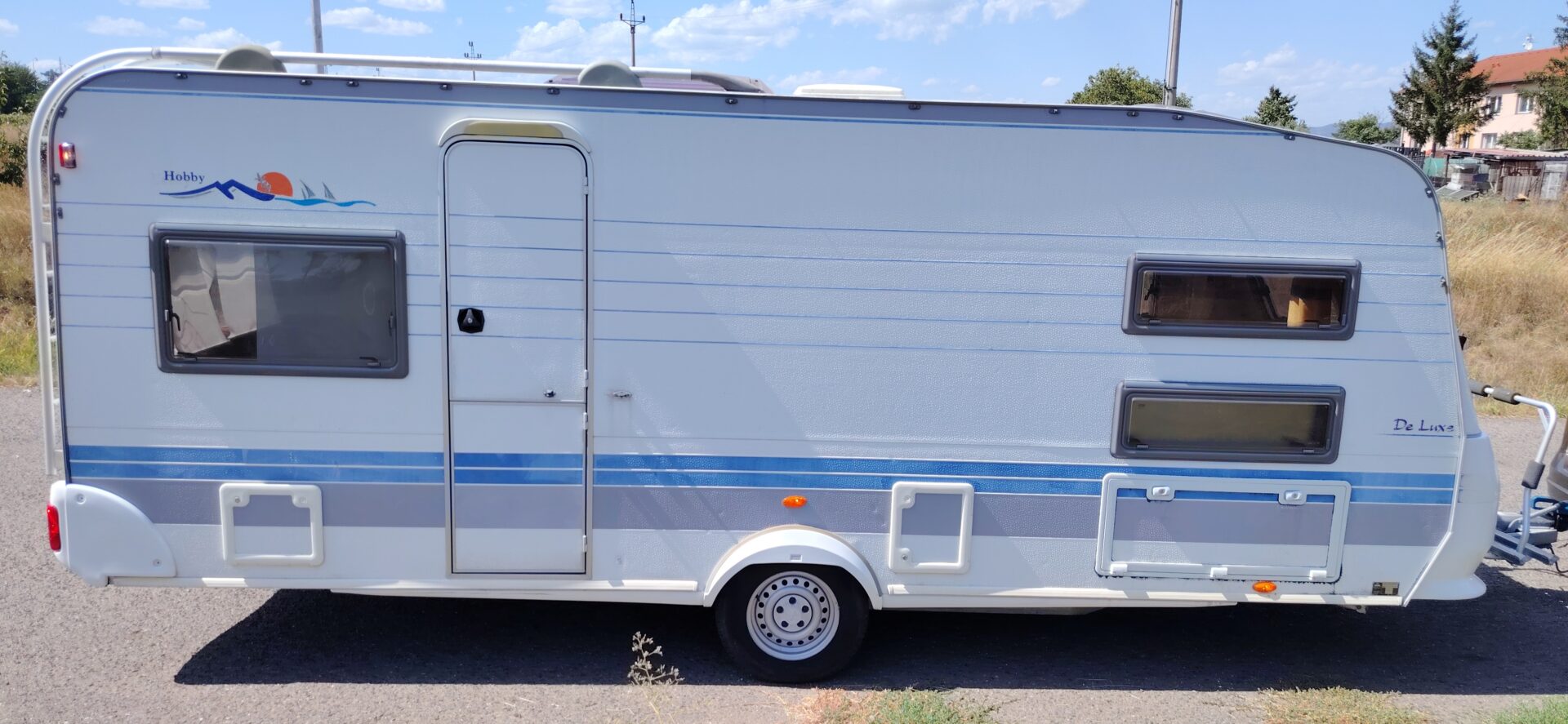 Karavan Hobby De Luxe, ideální pro pohodlné cestování a kempování. Vhodný pro rodiny a dobrodružné výlety.