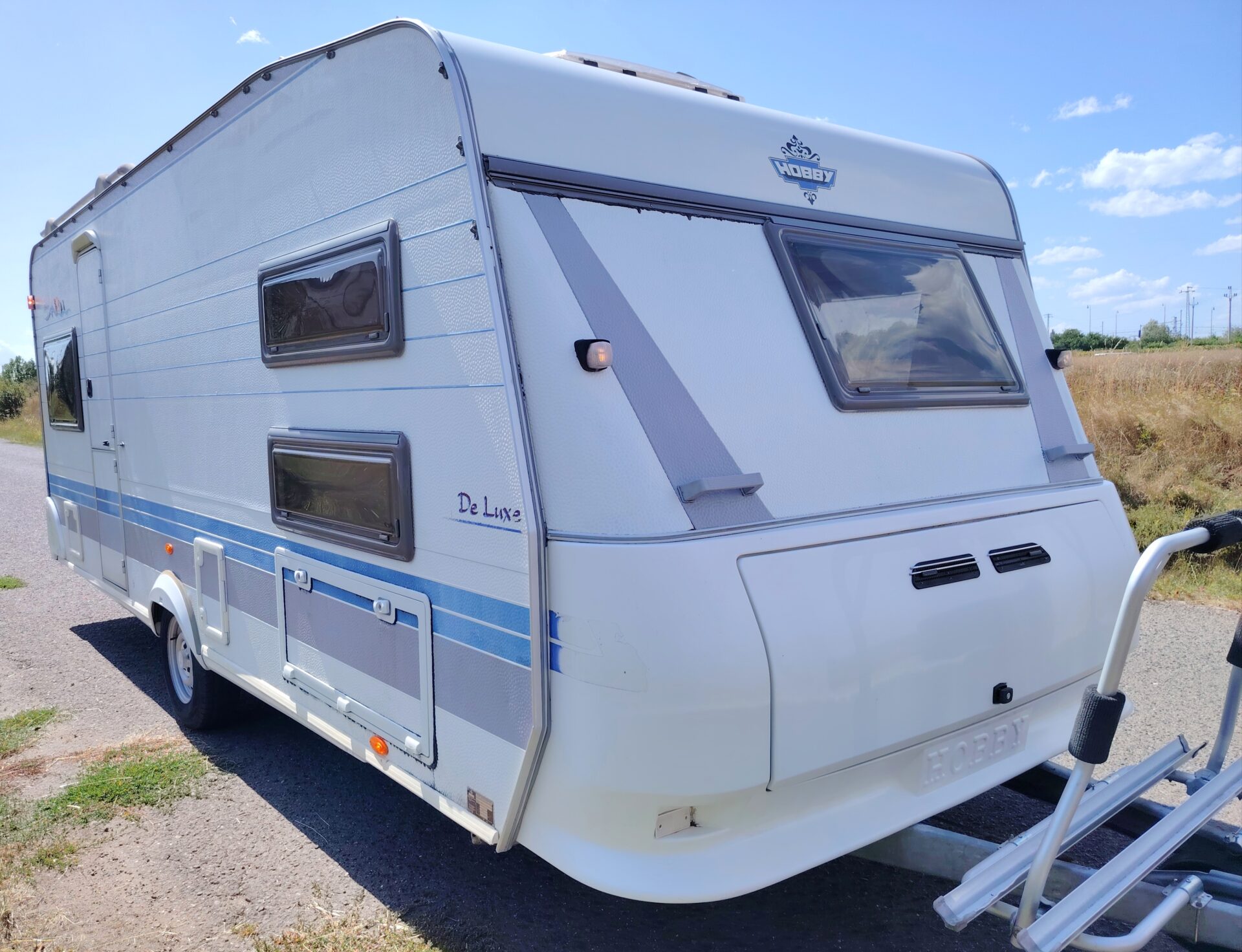 Karavan Hobby De Luxe, ideální pro komfortní kempování s rodinou nebo přáteli. Užívejte si dobrodružství na cestách!