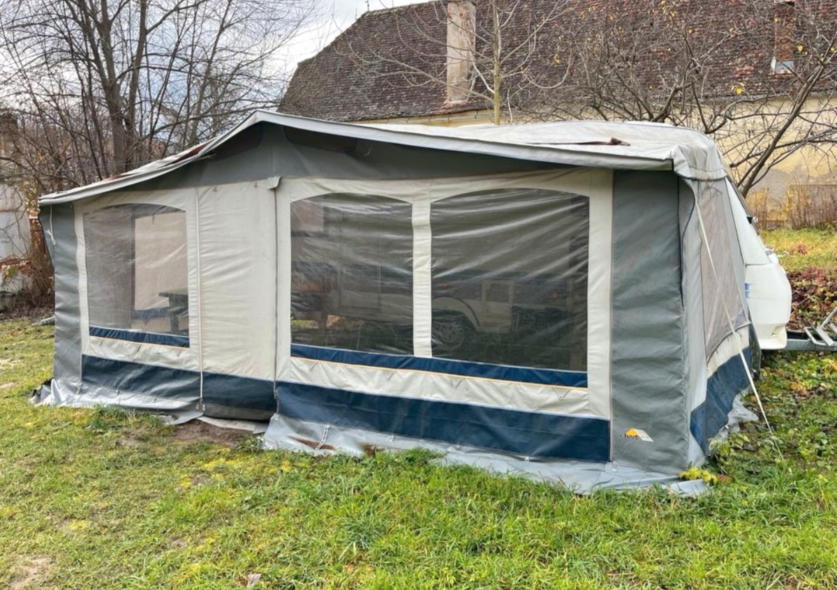 Obrázek zobrazuje karavan s prostornou konstrukcí a průhlednými okny. Ideální pro kempování!