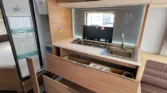 Stylový interiér obytného vozu s moderní kuchyní a dostatkem úložného prostoru. Ideální pro cestování a dobrodružství.