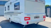 Karavan Adria Adora v bílém provedení, ideální pro pohodlné cestování a dovolenou.