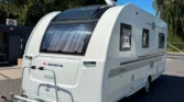 Karavan Adria Adora, moderní design, ideální pro rodinné výlety a dobrodružství v přírodě.