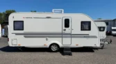 Karavan Adria Adora S522 UP v elegantním bílém designu, ideální pro komfortní cestování.