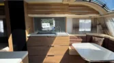 Obrázek znázorňuje interiér moderního karavanu s elegantním designem a pohodlnou jídelnou.